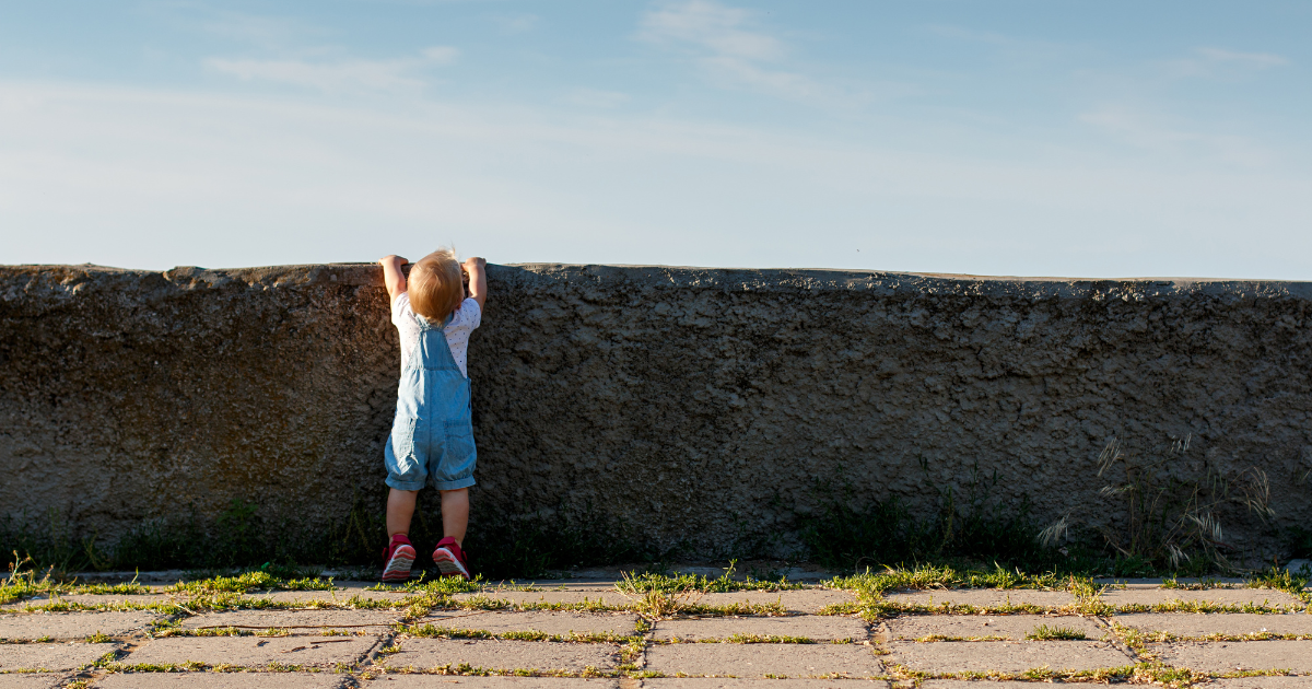 Young child looking over a wall